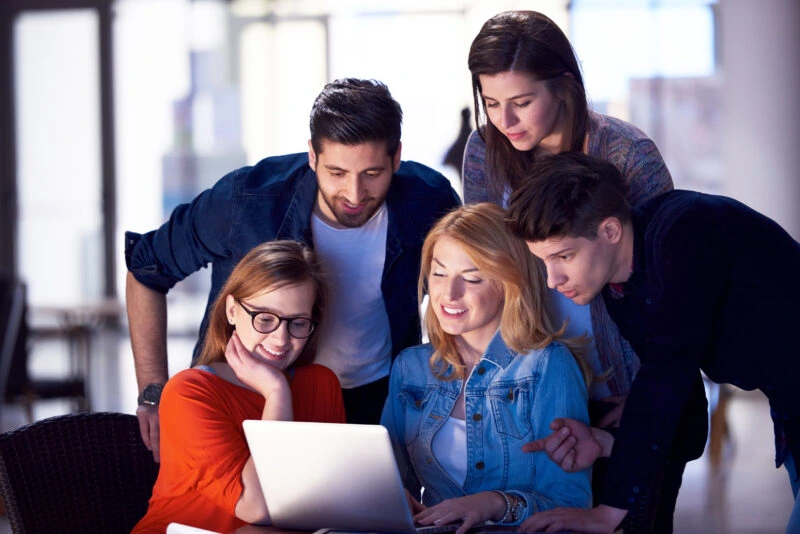 group of people looking at a laptop